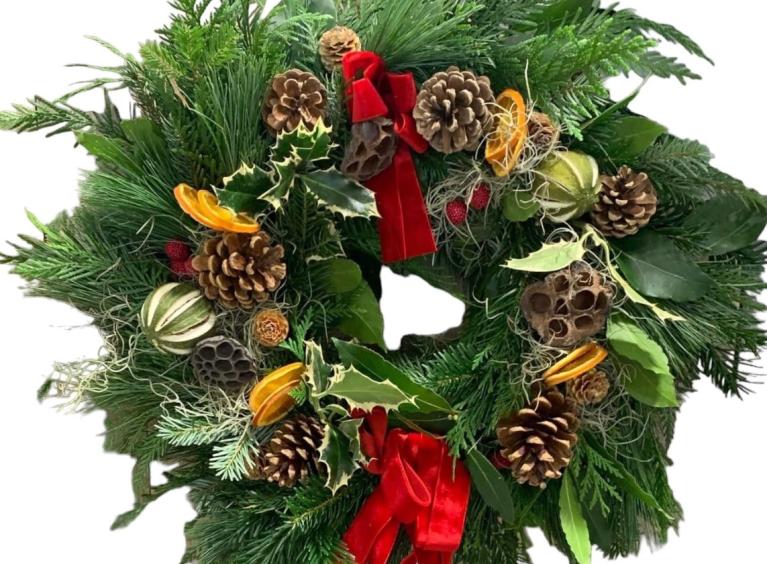 Christmas wreath with pinecones, orange slices and red ribbon