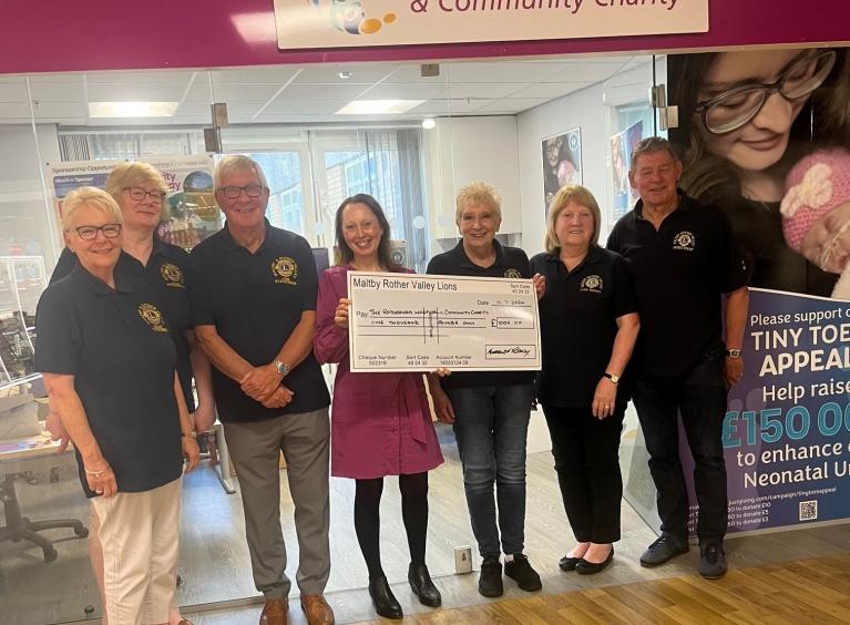 Members of Maltby and Rother Valley Lions presenting a large cheque outside the Rotherham Hospital and Community Charity Hub.