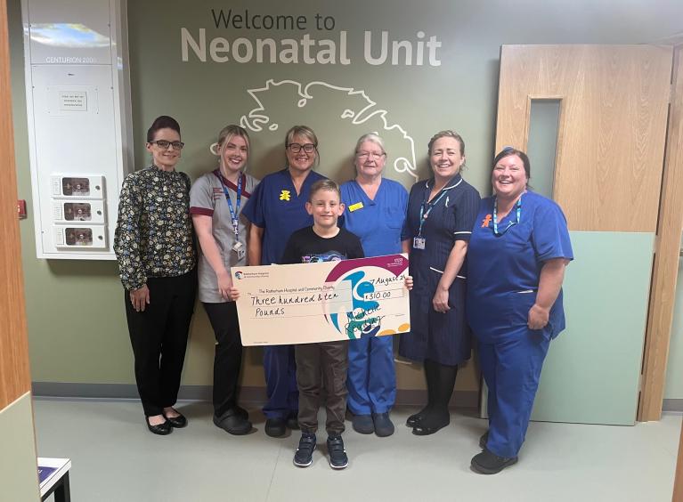 A group of 5 nurses, along with Michelle Reading and son Max who is holding a large cheque