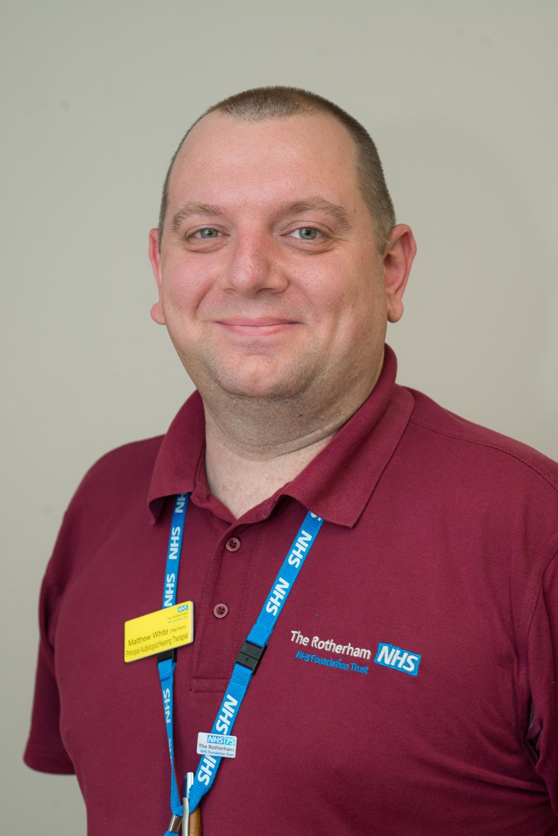 Matthew White wearing a maroon t-shirt with the Trust's logo