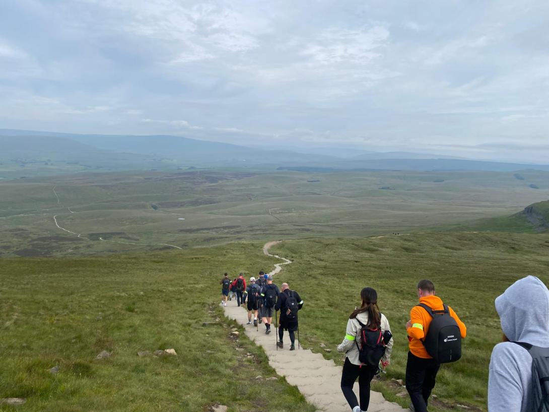 A group of people walking along a path in the Yorkshire Dales